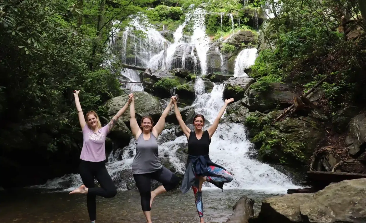 Yoga Angels students in tree pose at a waterfall